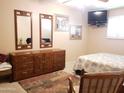 Comfortable bedroom featuring neutral walls, decorative mirrors, and a flat-screen TV, creating a relaxing retreat at 10112 N 96Th Ave # A, Peoria, AZ 85345