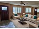 Bright living room featuring neutral furniture, a large window, decorative pillows, and a stylish coffee table at 10112 N 96Th Ave # A, Peoria, AZ 85345
