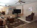 Cozy living room featuring a large mirror wall, a ceiling fan, and comfortable furniture, perfect for relaxing at 10112 N 96Th Ave # A, Peoria, AZ 85345