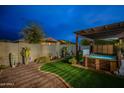 Backyard featuring artificial grass, a cozy pergola, and a private hot tub at 10246 W Oberlin Way, Peoria, AZ 85383