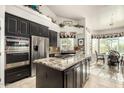 Spacious kitchen with granite countertops, stainless steel appliances, and dark wood cabinetry at 11336 N 117Th Way, Scottsdale, AZ 85259