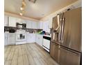 Bright kitchen features stainless steel appliances, white cabinetry and mosaic tile backsplash at 12046 W Scotts Dr, El Mirage, AZ 85335