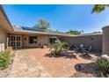 Private front courtyard with brick pavers, desert landscaping, and seating area at 12822 W Ballad Dr, Sun City West, AZ 85375