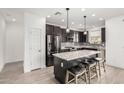 Modern kitchen boasts granite counters, an island with seating, and stainless steel appliances at 14254 W Honeysuckle Dr, Surprise, AZ 85387