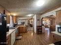 Functional kitchen with wood cabinets, a black refrigerator, and a view to the living area at 15001 W Camdon Dr, Casa Grande, AZ 85194