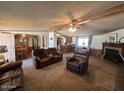 Comfortable living room with a ceiling fan, a fireplace, and cozy leather furniture at 15001 W Camdon Dr, Casa Grande, AZ 85194