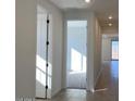 Bright hallway with neutral walls and floors, multiple doors, and recessed lighting throughout at 15818 W Hackamore Dr, Surprise, AZ 85387