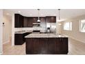 Modern kitchen with dark cabinets, granite countertops, stainless steel appliances and an island at 1966 E Pebble Beach Dr, Tempe, AZ 85282