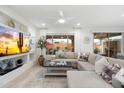 The cozy living room features recessed lighting, a sectional sofa, and a large flat-screen television at 20331 N Wagner Wash Dr, Buckeye, AZ 85396