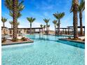 Resort-style pool with palm trees and comfortable lounge area, perfect for relaxation and entertainment at 23139 E Lords Way, Queen Creek, AZ 85142