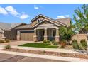 Attractive single-Gathering home featuring stone accents, a brick driveway, and a perfectly manicured front lawn at 23146 E Canary Way, Queen Creek, AZ 85142