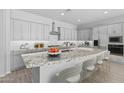 Modern kitchen showcasing gray cabinets, a large granite island, stainless steel appliances, and bar stool seating at 23146 E Canary Way, Queen Creek, AZ 85142