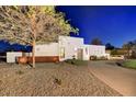 Modern home with desert landscaping, stone accents, and a circular driveway at dusk at 31 E Bishop Dr, Tempe, AZ 85282
