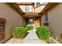 Inviting entryway with a decorative door, manicured shrubbery, and a charming pathway to the entrance at 4297 E Pyrenees Ct, Gilbert, AZ 85298