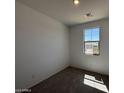 Bright bedroom with plush gray carpeting, natural light from the window, and neutral walls creating a relaxing atmosphere at 47734 W Moeller Rd, Maricopa, AZ 85139