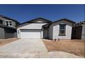 A single-story home with a white stucco finish, complemented by a 2-car garage and desert landscaping in the front yard at 47734 W Moeller Rd, Maricopa, AZ 85139