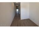 Long hallway featuring stylish wood-look tile flooring, bright lighting, and smooth white walls, providing a modern feel at 47734 W Moeller Rd, Maricopa, AZ 85139