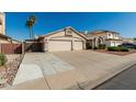 Beautiful exterior of home with large driveway, a three-car garage, and desert landscaping at 654 W Natal Cir, Mesa, AZ 85210