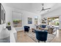 Bright living room featuring stylish blue chairs, a ceiling fan, and sliding glass doors at 7544 E Sierra Morena Cir, Mesa, AZ 85207