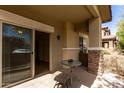 Relaxing outdoor patio featuring a sliding glass door, stone accents and stylish patio furniture at 7726 E Baseline Rd # 134, Mesa, AZ 85209