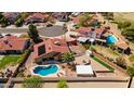 Aerial view of a home with a private pool, lush landscaping, and a charming backyard at 7726 W Cameron Dr, Peoria, AZ 85345