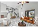 Open concept living room with staircase, neutral colors, light flooring and statement lighting at 913 W Juanita Ave, Gilbert, AZ 85233