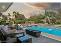 Luxurious pool area featuring a modern fire pit and tranquil water features, surrounded by lush landscaping at 10524 E Cannon Dr, Scottsdale, AZ 85258