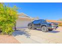 View of the home's side exterior with a well-maintained garage and adjacent driveway at 11816 S Winnebago St, Phoenix, AZ 85044