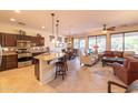 Open-concept living area boasts tile floors, ceiling fan, and a living space with a leather sofa at 13068 W Mine Trl, Peoria, AZ 85383