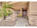 View of the front porch, featuring a seating area and decorative stone columns, with a door to the home at 1409 E Mayfield Dr, San Tan Valley, AZ 85143
