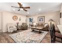 Cozy living room featuring a ceiling fan, beautiful decor, and an eye-catching patterned rug at 1557 S Halsted Dr, Chandler, AZ 85286