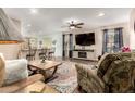 Cozy living room seamlessly flowing into the kitchen and dining area, with a ceiling fan and patterned rug at 1557 S Halsted Dr, Chandler, AZ 85286