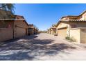 Wide angle of the well-maintained street and townhome community with individual garages at 29120 N 22Nd Ave # 205, Phoenix, AZ 85085