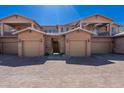 View of multi-unit townhome showcasing well-maintained exteriors, garages, and paver driveway at 29120 N 22Nd Ave # 205, Phoenix, AZ 85085
