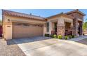 Charming home featuring a spacious driveway, stone accents, and a two-car garage at 3285 E Phelps St, Gilbert, AZ 85295