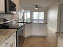 Modern kitchen with granite countertops, white cabinets, and stainless steel appliances at 3758 E Ironwood Dr, Phoenix, AZ 85044
