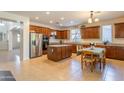 Well-lit kitchen features stainless steel appliances, granite counters, an island and ample cabinet space at 549 W Sweet Shrub Ave, Queen Creek, AZ 85140