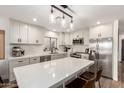 Modern kitchen boasts sleek white cabinets, stainless steel appliances, and a spacious center island at 6526 W West Wind Dr, Glendale, AZ 85310