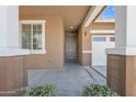 Covered front porch with stone columns, view of front door, and landscaped entrance at 7115 E Olla Ave, Mesa, AZ 85212