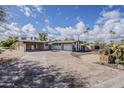 Charming home featuring a long driveway, a two-car garage, mature palm trees, and desert-friendly landscaping at 7131 E Cholla St, Scottsdale, AZ 85254