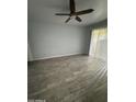 Living room with wood-style flooring, ceiling fan, and natural light from the sliding doors at 8101 N 107Th Ave # 26, Peoria, AZ 85345