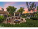 Inviting backyard patio with seating around a fire pit, a gazebo, and a charming rock waterfall feature at 8260 W Cielo Grande Ave, Peoria, AZ 85383