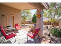 Covered patio with outdoor furniture overlooking a well maintained backyard with shade trees and plants at 85 W Grey Stone St, San Tan Valley, AZ 85143