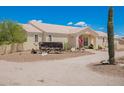 Front view of single-story home with desert landscaping, covered entryway, and a vintage wagon on the property at 9736 E Sleepy Hollow Trl, Gold Canyon, AZ 85118