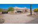 Side view of single-story home with desert landscaping, covered entryway, and a vintage wagon on the property at 9736 E Sleepy Hollow Trl, Gold Canyon, AZ 85118