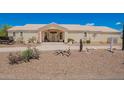 Wide front view of a well-maintained single-story house with desert landscaping and covered entryway at 9736 E Sleepy Hollow Trl, Gold Canyon, AZ 85118