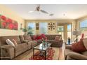 Comfortable living room with a cozy sectional, ceiling fan, and bright natural light at 10037 W Watkins St, Tolleson, AZ 85353