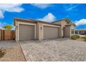 A well-maintained single-Gathering house with a three-car garage and low-maintenance desert landscaping at 1211 E Jahns Dr, Casa Grande, AZ 85122