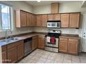 Well-lit kitchen with stainless steel appliances, wooden cabinets, and tile flooring at 1225 N 36Th St # 1054, Phoenix, AZ 85008