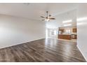 Spacious living room featuring modern wood floors, ceiling fan, and plenty of natural light at 12325 W Charter Oak Rd, El Mirage, AZ 85335